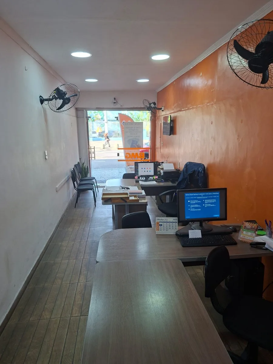 Sala de atendimento do Grupo Real, com mesas de trabalho e entrada iluminada pela rua