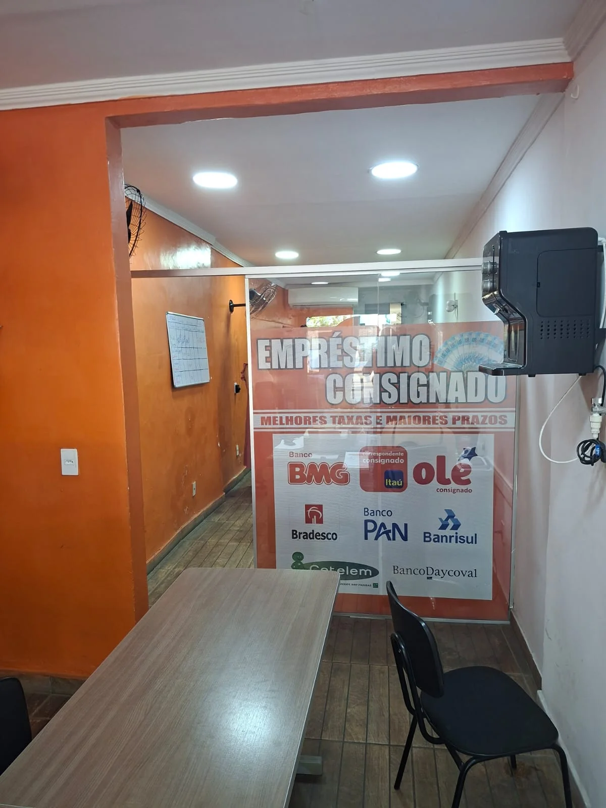 Vidro de entrada do Grupo Real com a sinalização de Empréstimo Consignado e os bancos parceiros